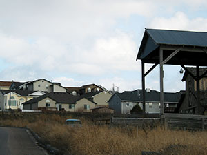 Chubbuck real estate is a mix of rural acreages and modern subdivisions Rustic barn roof in foreground, modern residences in background